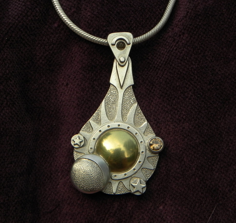 Silver pendant with sun, moon and stars